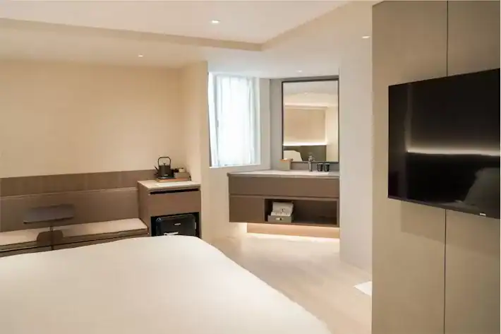 塔木德酒店索羅斯雙人套房，房內設有一張大床與舒適休憩空間，搭配柔和燈光與簡約設計，營造出高雅寧靜的住宿氛圍，適合情侶或商務旅客入住。