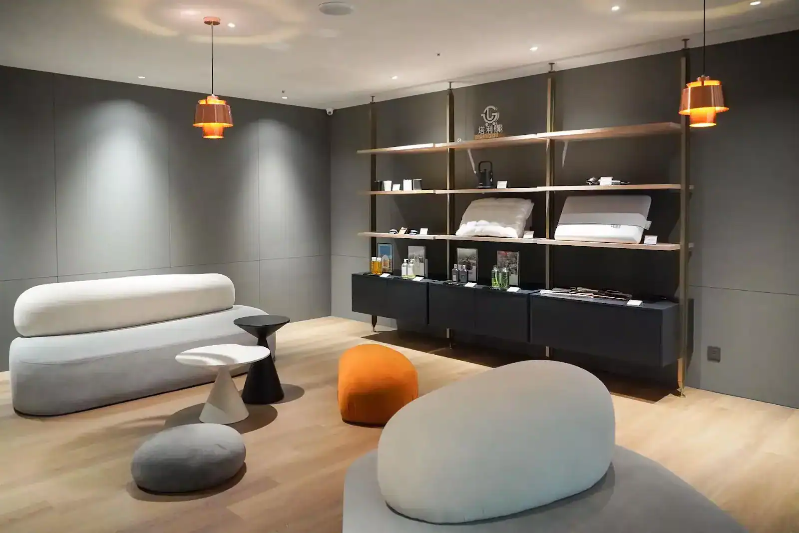 飯店交誼空間採現代極簡設計，柔和燈光搭配圓弧沙發與展示架，營造舒適雅緻氛圍