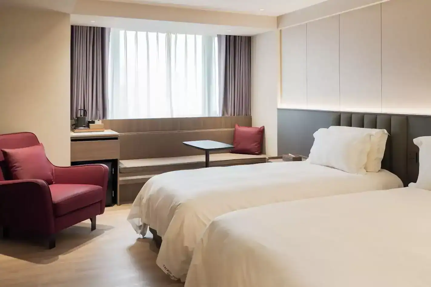 塔木德酒店台中館現代雙床客房，設有沙發與自然採光窗
