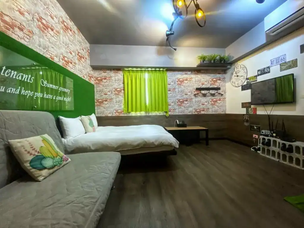 一中街藻宿雙人房設計風格活潑，牆面以紅磚與綠意裝飾，近夜市且性價比高，適合小資旅人選擇。