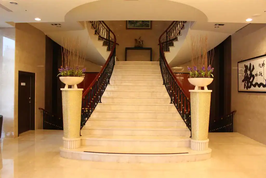 中科大飯店內部樓梯，對稱設計與花藝裝飾展現古典氣息