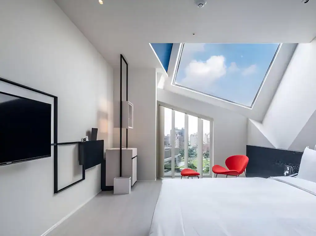 挑高天窗與城市景觀相映的現代客房空間