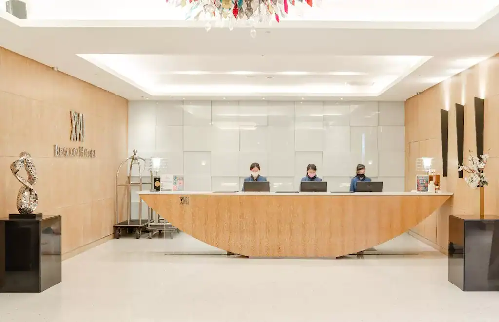 飯店櫃台大廳明亮整潔，櫃台人員服務親切，木質設計展現典雅氛圍