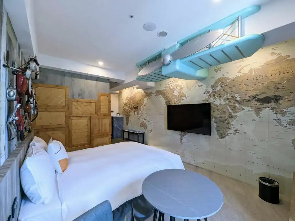 台中商務旅館久窩旅店一中館的主題風格客房，具世界地圖與飛機裝飾設計。