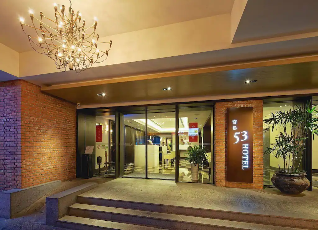 台中商旅寶島53行館的大廳入口，溫暖燈光映照紅磚外牆，呈現舒適典雅的迎賓氛圍。