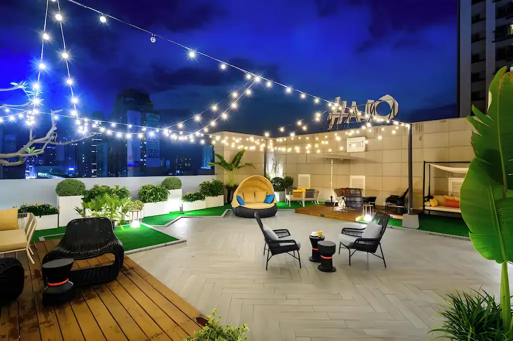 悅樂旅店台中文心的頂樓露台夜景，串燈點亮舒適休憩座位區，呈現浪漫又放鬆的城市夜晚氛圍。